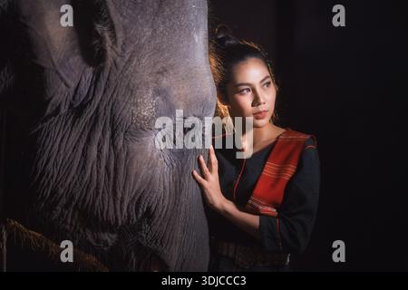 Ritratto ravvicinato di una bella donna che tocca affettuosamente la testa di un elefante, Surin, Thailandia Foto Stock
