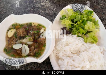 Il Bun Cha è un piatto tradizionale vietnamita, tipicamente costituito da maiale alla griglia servito con spaghetti di vermicelli e un contorno di salsa per immersione. Foto Stock