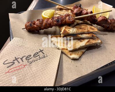 Street Souvlaki, Atene, Grecia. Cibo di strada greco, spiedini di souvlaki, pane pita, limone. Foto Stock