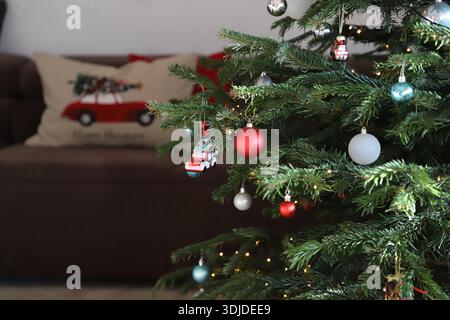 Un albero di Natale decorato con palline bianche, rosse e blu in una camera. Foto Stock