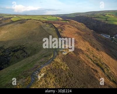 Vista aerea della luce del sole dorata che bacierà le aspre scogliere e i campi verdi, divisi da mura di pietra, Boscastle, Inghilterra, Regno Unito. Foto Stock