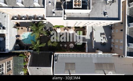 Vista aerea di una piscina nel cortile che riflette il cielo, annidata tra gli edifici, New Orleans, Louisiana, Stati Uniti. Foto Stock
