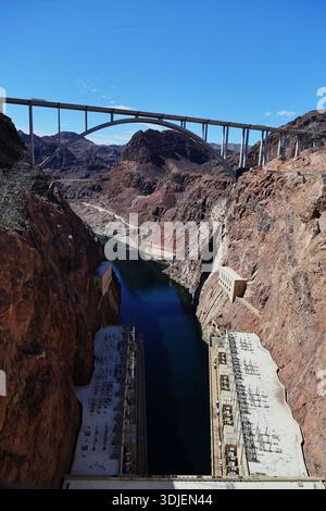 Complesso idroelettrico della diga di Hoover sul confine con il Nevada, Arizona, negli Stati Uniti, visto sotto il ponte ad arco che attraversa un canyon fluviale con terreno roccioso. Foto Stock