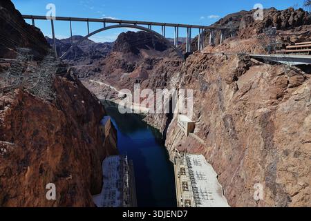 Sito idroelettrico della diga di Hoover al confine con il Nevada, Arizona, negli Stati Uniti, con torri d'acciaio, linee elettriche e ponte di bypass sopra il fiume alla luce del giorno. Foto Stock