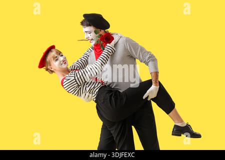 Un paio di pantomimisti danzanti su sfondo giallo Foto Stock