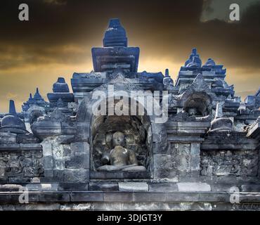 Dettaglio architettonico del Tempio di Borobudur con una statua di Buddha seduta all'interno di una nicchia di pietra, Giava centrale, Indonesia. Foto Stock