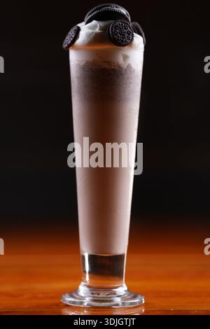 Frullato di biscotti e panna con panna montata e biscotti sandwich al cioccolato. Foto Stock