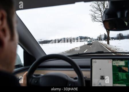 Baviera, Germania - 26 gennaio 2025: Vista da un'auto su una strada di campagna invernale con neve e possibili condizioni scivolose. L'immagine rappresenta la guida in inverno, una maggiore cautela in condizioni di ghiaccio e l'importanza di adattare lo stile di guida per la sicurezza stradale. *** Blick aus dem Auto auf eine winterliche Landstraße mit Schnee und möglicher Glätte. DAS Bild steht für Autofahren im Winter, erhöhte Vorsicht bei Eis und die Bedeutung angepasster Fahrweise zur Verkehrssicherheit. Foto Stock