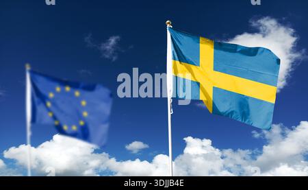La bandiera della Svezia membro dell'UE fluttua contro un cielo limpido. Volare nel cielo. La bandiera UE in lontananza è intenzionalmente sfocata nella foto. Foto Stock