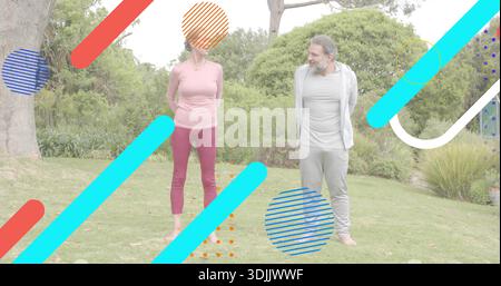 Donna e uomo in piedi di fronte all'altro in giardino che indossano abbigliamento sportivo con sovrapposizioni grafiche Foto Stock