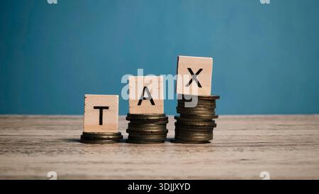 Pile di monete ascendenti con BLOCCHI FISCALI su sfondo blu che rappresentano l'onere fiscale Foto Stock