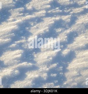Superficie innevata scintillante con ombre morbide e luce naturale, per creare uno sfondo invernale dalla texture. Foto Stock