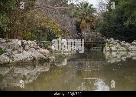 Giardino nazionale di Atene (Εθνικός Κήπος). Ponte rustico in legno sul lago centrale. Parco storico fondato negli anni '1830 ad Atene, Grecia. Foto Stock
