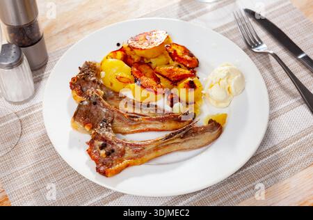 Costolette di agnello alla griglia con patatine fritte sul piatto Foto Stock
