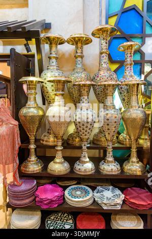 Vivace ripresa verticale di vasi tradizionali in ottone con fantasie intricate e piatti decorativi colorati con design orientale, perfetti per l'arredamento e la casa Foto Stock