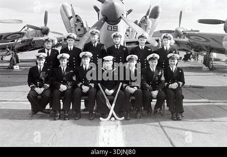 La squadra della HMS Glory posa per una foto di gruppo, citata come scattata nel 1953 durante una visita a Malta, di ritorno dal servizio attivo nella guerra di Corea. HMS Glory (R62) è stata una portaerei classe Colossus della Royal Navy varata il 27 novembre 1943 e dismessa nel 1956. La HMS Glory fu schierata in Corea nell'aprile 1951 per il primo di tre schieramenti in tempo di guerra. Il primo dispiegamento terminò nel settembre di quell'anno, ma Glory tornò in stazione da gennaio a maggio 1952 e da novembre 1952 a maggio 1953. Gruppo che posa sul ponte con bastoncini da hockey, seduto di fronte al Fairey Firefly Aircraft Foto Stock