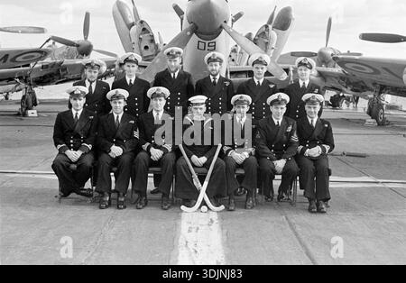 La squadra della HMS Glory posa per una foto di gruppo, citata come scattata nel 1953 durante una visita a Malta, di ritorno dal servizio attivo nella guerra di Corea. HMS Glory (R62) è stata una portaerei classe Colossus della Royal Navy varata il 27 novembre 1943 e dismessa nel 1956. La HMS Glory fu schierata in Corea nell'aprile 1951 per il primo di tre schieramenti in tempo di guerra. Il primo dispiegamento terminò nel settembre di quell'anno, ma Glory tornò in stazione da gennaio a maggio 1952 e da novembre 1952 a maggio 1953. Gruppo che posa sul ponte con bastoncini da hockey, seduto di fronte al Fairey Firefly Aircraft Foto Stock