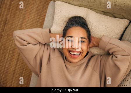 Direttamente sopra l'immagine di una donna matura felice sdraiata sul divano di casa Foto Stock