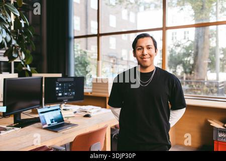 Ritratto di un architetto maschio in piedi con le mani dietro nel nuovo ufficio Foto Stock