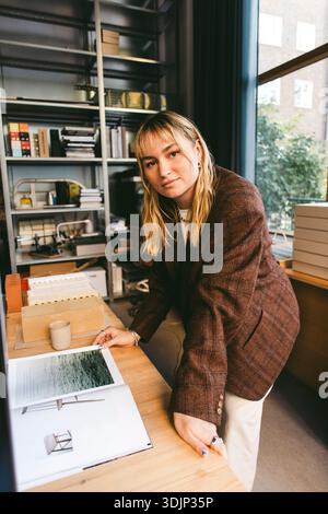 Ritratto ad alto angolo di una giovane architetto sicura di sé appoggiata alla scrivania nel nuovo ufficio Foto Stock