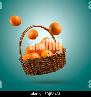 Un mazzo di frutta fresca matura in un cestino di vimini che salta su sfondo blu. Foto Stock
