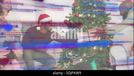 Raggiungere l'uomo nel cappello di Babbo Natale inginocchiato vicino all'albero di Natale in salotto, accettando un grande regalo confezionato Foto Stock