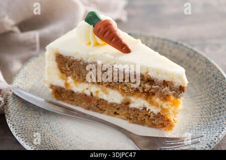 Fetta di torta di carote con glassa di formaggio cremoso su un tavolo di legno. Foto Stock
