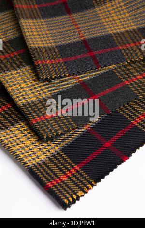 Una foto dall'alto verso il basso e angolata mostra tre campioni sovrapposti di pesante tessuto di lana con un classico motivo a quadri tartan in grigio antracite, mus Foto Stock