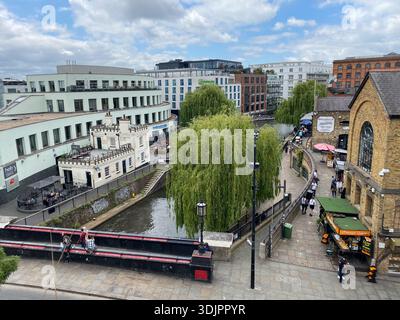 Vista aerea di Camden Lock a Londra, che mostra barche strette, salici, magazzini storici, bancarelle del mercato e pedoni lungo il percorso della città Foto Stock
