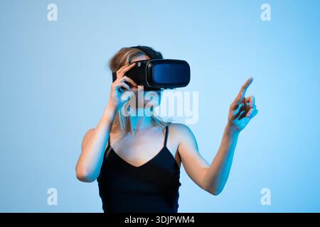 Donna creativa che lavora in un ambiente di realtà virtuale con gesti delle mani, design VR e concetto di interfaccia digitale Foto Stock
