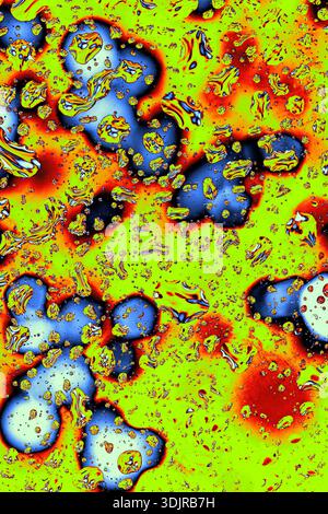 Bolle luminose di liquido blu su sfondo giallo-verde con accenti rossi, texture lucida e forme astratte. Fotografia macro dall'alto Foto Stock