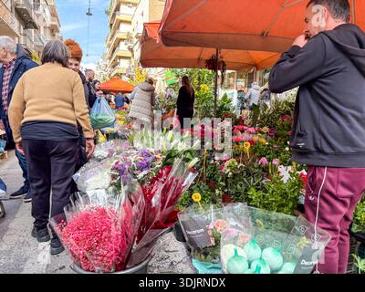 Mercato di via Kallidromiou, Laiki Agora. Gli amanti dello shopping curiosano tra le vivaci bancarelle di fiori del popolare mercato agricolo del fine settimana a Exarcheia, Atene, Grecia. Foto Stock