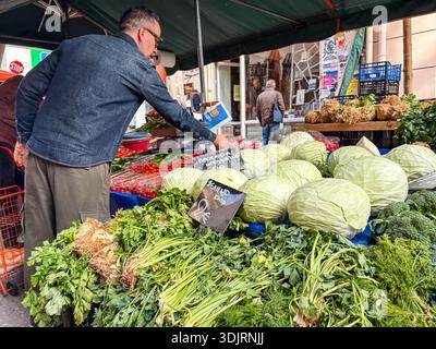 Mercato di via Kallidromiou (Laiki Agora) che vende cavolo fresco, erbe e verdure in una stalla ad Atene, Grecia. Autentica scena dello shopping greca. Foto Stock