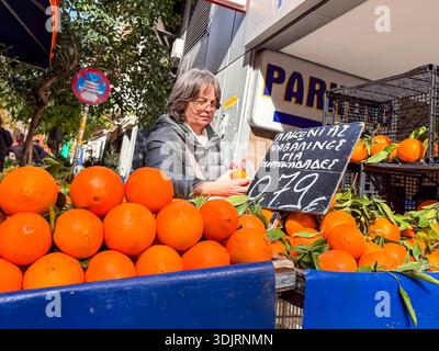 Mercato di via Kallidromiou (Laïkí Agorá), Exarchia, Atene. Scena autentica di una donna che vende arance Navel fresche presso il colorato cibo locale Foto Stock