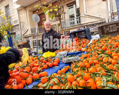 Mercato di via Kallidromiou, Laiki Agora. Venditore di clementine fresche o mandarini in una stalla all'aperto ad Atene, Grecia. Foto Stock