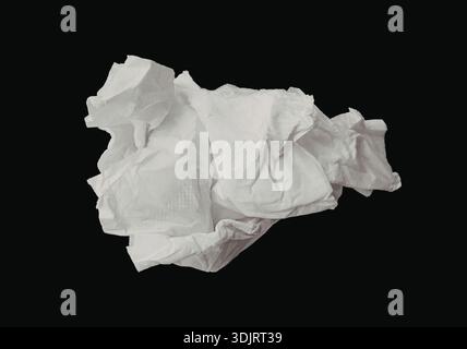 Immagine ravvicinata di un singolo pezzo di carta bianca sgualcita su uno sfondo nero scuro. La carta sembra essere stropicciata in varie direzioni Foto Stock