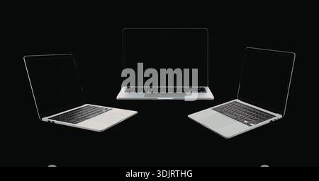 Immagine monocromatica con tre laptop visualizzati in varie angolazioni su sfondo nero. Foto Stock