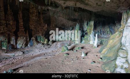 Una grande grotta interna con stalattiti e stalagmiti, poco illuminata. Sokotra, Yemen. Foto Stock