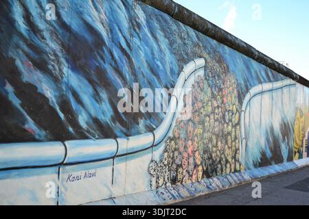 Berlino, Germania – murale presso la East Side Gallery su una sezione conservata del muro di Berlino, che simboleggia la divisione e l'unità nella storia europea moderna. Foto Stock