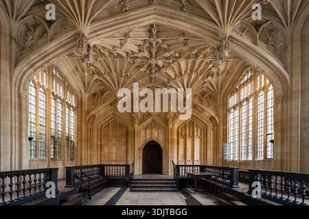 Interno della Divinity School presso la Bodleian Library di Oxford, con soffitto a volta in pietra e architettura gotica Foto Stock