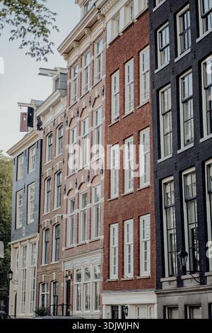 Le case e le facciate dei canali di Amsterdam lungo un Gracht olandese, architettura classica che si riflette nell'acqua. «» Foto Stock