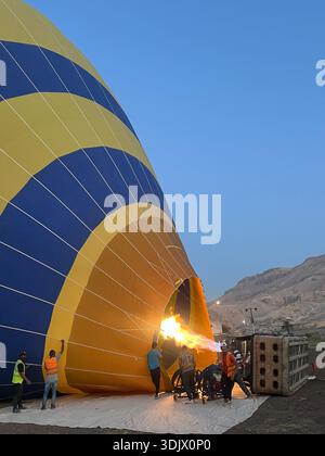 Una mongolfiera in fase di gonfiaggio nella valle di Luxor, in Egitto, la mattina presto Foto Stock