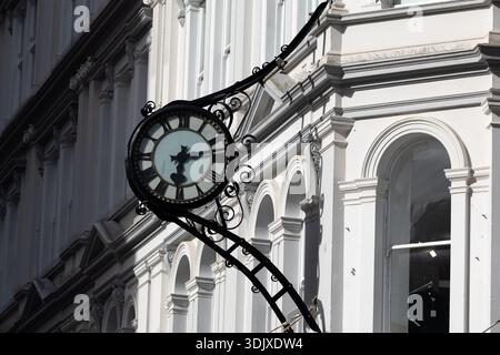 Un orologio da strada ornato montato su una facciata di un edificio storico nel centro di Auckland, nuova Zelanda. Foto Stock