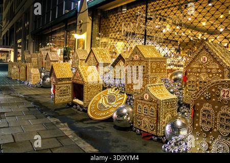 Vetrina natalizia con una collezione di grandi case di pan di zenzero decorate in modo complesso che fungono da calendario interattivo dell'avvento. Foto Stock