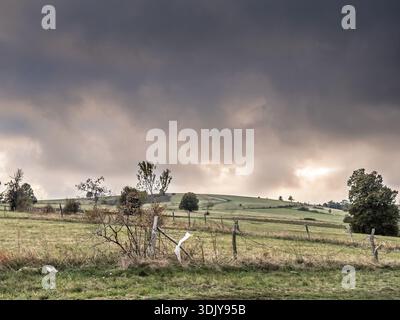 Vista panoramica delle colline verdi ondulate e dei campi agricoli sotto il cielo nuvoloso drammatico a Vrh Rajac, Serbia. Il Rajac è una montagna di Sumadija, parte di di Foto Stock