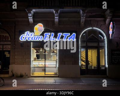 SUBOTICA, SERBIA - 16 NOVEMBRE 2025: L'insegna al neon illuminata di "Ice Cream Elita" sopra l'ingresso di un negozio di dolci di notte a Subotica, un gelato Foto Stock