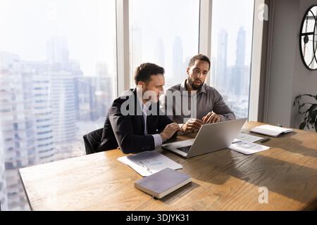 Due diversi partner commerciali maschili che discutono di progetti online Foto Stock