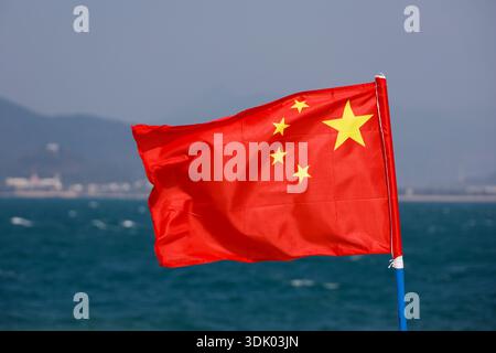 Bandiera della Cina sullo sfondo blu del cielo e del mare Foto Stock