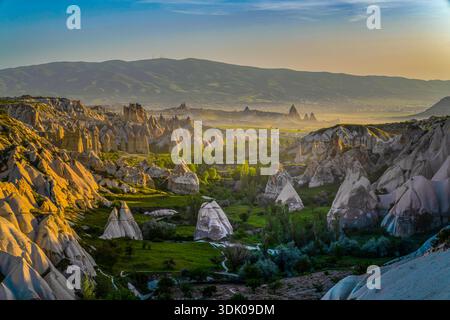Vista panoramica dei camini delle fate e delle formazioni rocciose vulcaniche nella valle della Cappadocia all'alba, Turchia Foto Stock