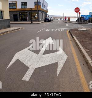 Segnali stradali direzionali di forma interessante sul fondo stradale, El Cotillo, Fuerteventura, Isole Canarie, Spagna, UE. Foto Stock